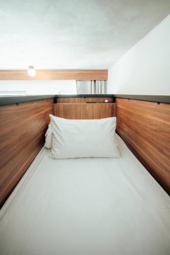 a bed in a room with a wooden headboard at JOST Hôtel Bordeaux Centre Gare Saint Jean in Bordeaux