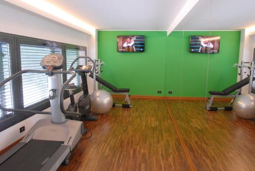 un gimnasio con cinta de correr y pared verde en Hotel Sole, en Giulianova