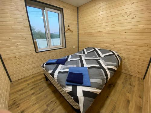 uma cama grande num quarto de madeira com uma janela em Ехо Природи em Kamianets-Podilskyi