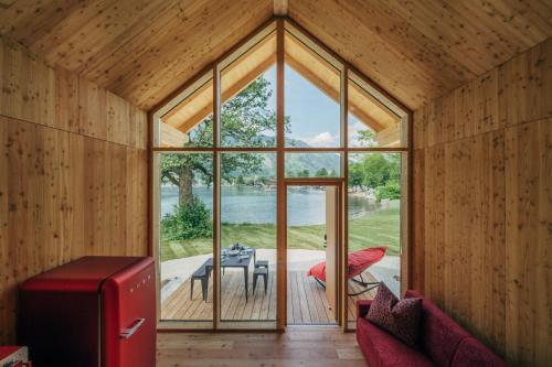 Zimmer mit einer großen Glastür und einem Tisch in der Unterkunft Eco Lodges Millstätter See in Döbriach