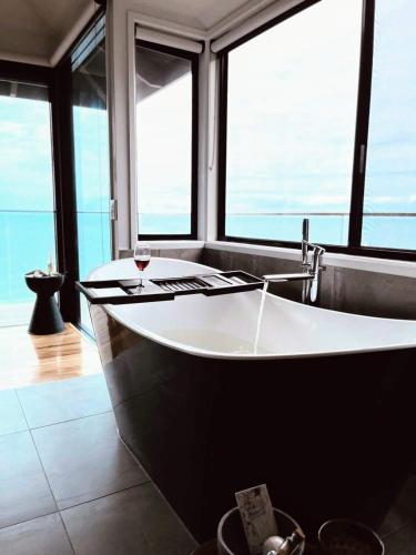 a large bath tub in a room with windows at The Deck House Wye River in Wye River