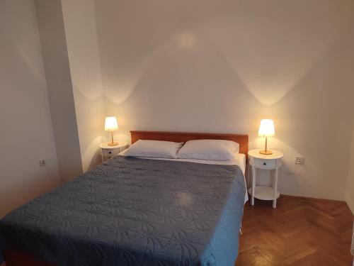 ein Schlafzimmer mit einem Bett und zwei Lampen an zwei Tischen in der Unterkunft Povljana Maris in Povljana