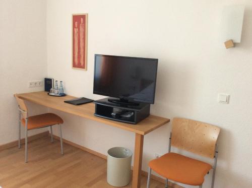 einen Schreibtisch mit einem TV darüber in der Unterkunft Gasthof Hotel Bauer in Hersbruck