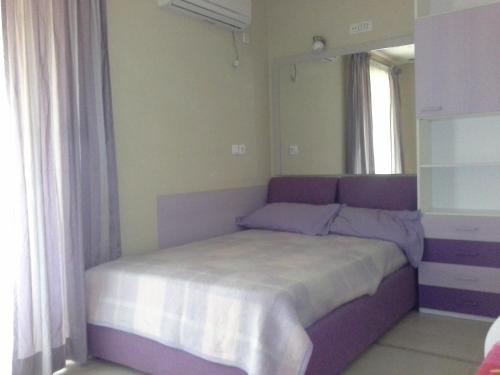 a bedroom with a purple bed with a mirror at 1этаж виллы на берегу Адриатики in Utjeha