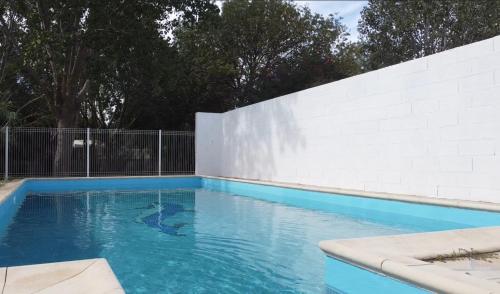 une piscine bleue avec un mur blanc dans l'établissement 
