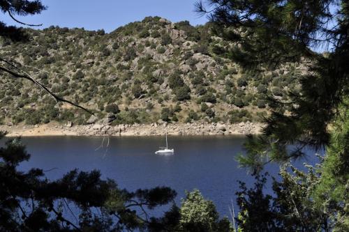 a boat sitting in the middle of a lake at La cabaña del Burguillo in El Barraco