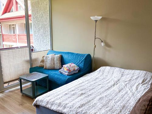 a bedroom with a bed and a couch and a window at Kitas krantas in Juodkrantė