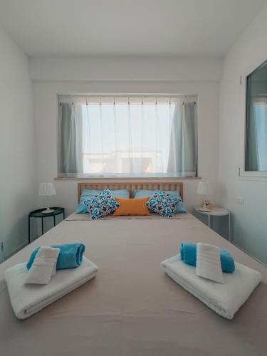 a bedroom with a large bed with blue and orange pillows at Misalmar - Appartamenti San Lorenzo 1 in Reitani