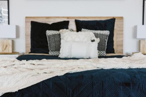 a bedroom with a bed with black and white pillows at The Deck House Wye River in Wye River