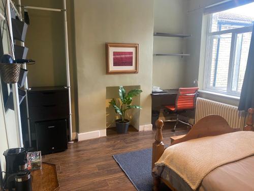 1 dormitorio con cama, escritorio y silla en Tranquil Garden View Double Room, en Londres
