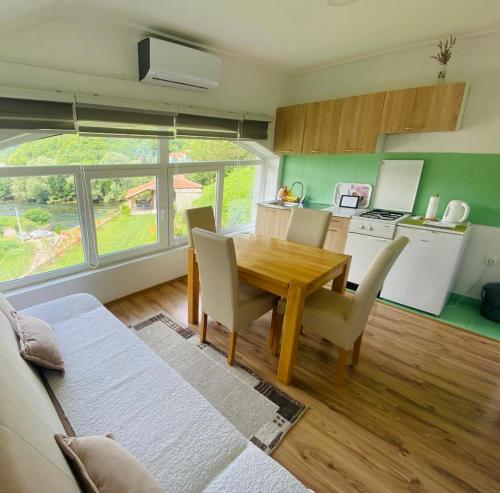 eine Küche und ein Esszimmer mit einem Holztisch und Stühlen in der Unterkunft Unaqua Apartments in Kulen Vakuf