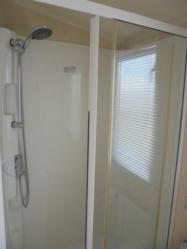 a shower with a glass door in a bathroom at Kingfisher : Soleil:- 6 Berth, Central Heated, Close to site entrance in Ingoldmells