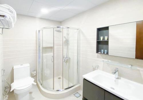a bathroom with a shower and a toilet and a sink at The Sea Loft Boutique Chalets in Manama