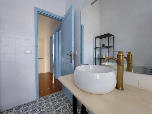 een witte badkamer met een wastafel en een spiegel bij Casa Mimosa with private pool & garden in Agaete
