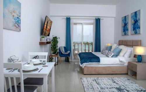 ラス・アル・ハイマにあるCozy Sea View Studio at Al Hamra by FREE Holiday Homesのベッドとダイニングルームのあるリビングルーム