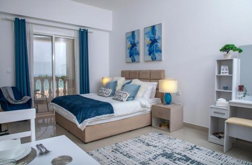 een slaapkamer met een groot bed met blauwe accenten bij Amazing sea view studio in Ras al Khaimah