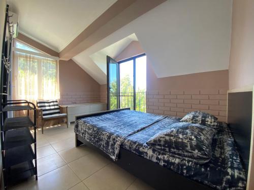 um quarto com uma cama e uma grande janela em Guest House Sophie em Gonio