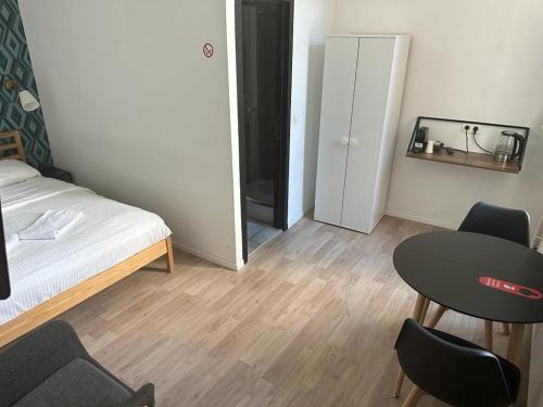 a small room with a bed and a table and chairs at BED Collège in Namur