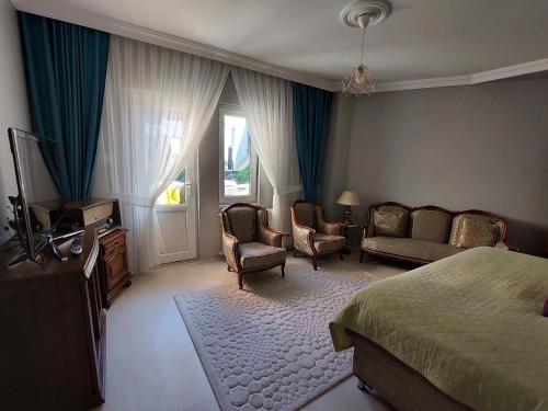 Villa Mercury (4 bedrooms and air conditioning) في طرابزون: غرفة نوم بسرير وكرسيين واريكة