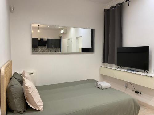 a room with a bed and a tv and a mirror at Cozy near the Barcelona Camp Nou Stadium in Barcelona