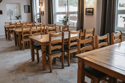 的住宿－Restaurace a penzion U svaté Barbory，用餐室配有木桌和椅子