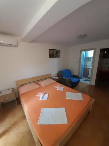 a bedroom with a large orange bed in a room at Apartments Kovačević in Petrovac na Moru