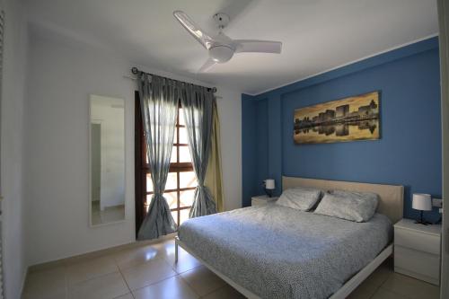 a bedroom with a bed and a blue wall at Favoloso trilocale a Las Americas in Arona