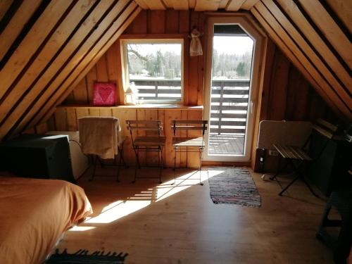 ein Schlafzimmer mit einem Bett und einem Fenster im Dachgeschoss in der Unterkunft Lili’s Holiday House in Otepää