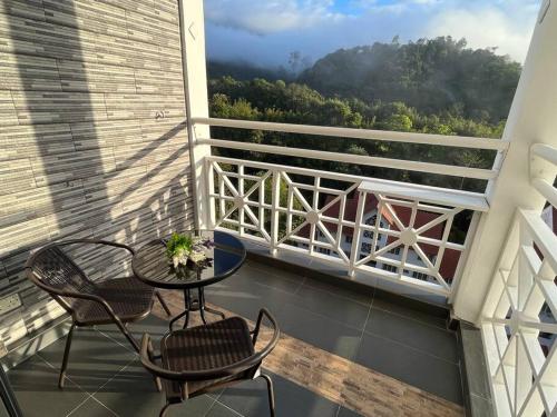 a balcony with a table and chairs and a view at The Van Gogh Loft at Selesa Hillhomes in Bukit Tinggi