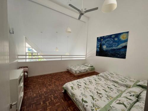 a bedroom with two beds and a painting on the wall at The Van Gogh Loft 梵高小栈 at Selesa Hillhomes in Bukit Tinggi