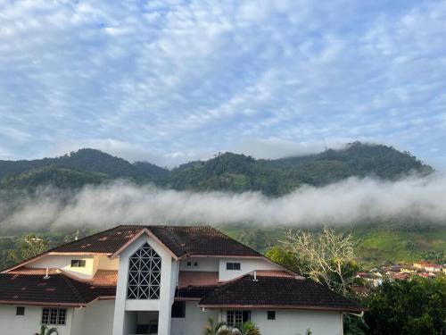 a view of a house with clouds in the mountains at The Van Gogh Loft at Selesa Hillhomes in Bukit Tinggi