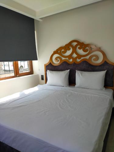 a bedroom with a large bed with a wooden headboard at Gala Otel Edirne in Edirne