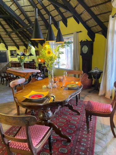 a dining room with a table and chairs and a clock at The Farm Shop in Groutfontein