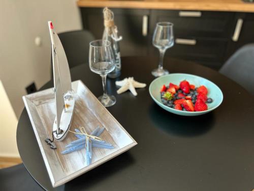 a black table with a plate of fruit and a knife at Studio Apartments Leut & Lanterna in Vis