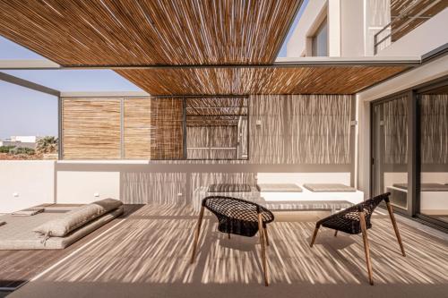 a living room with a couch and a table and chairs at Yenesis Seaside Retreat - Adults only over 15 in Tinos Town