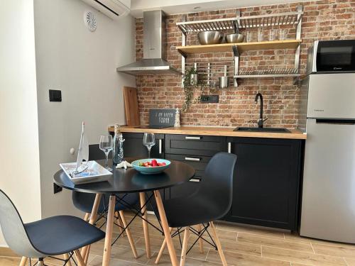 a kitchen with a table and chairs in a kitchen at Studio Apartments Leut & Lanterna in Vis