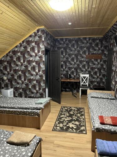 a room with two beds and a desk in it at Готель Максим Ресторан in Drogovyzhe