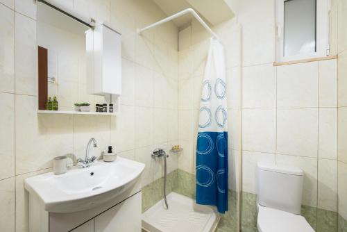 een badkamer met een wastafel, een toilet en een douchegordijn bij Villa Sophia-Elpis in Chersonissos