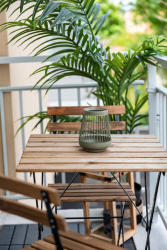 un vase assis sur une table en bois sur une terrasse couverte dans l'établissement Appart Neuf, parking et plage, à Andernos-les-Bains