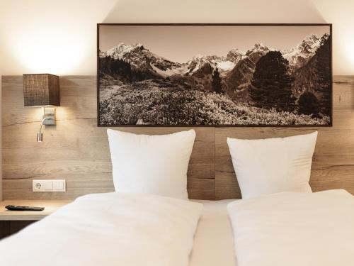 a bedroom with a bed with white pillows at MYALPS Pure in Oetz