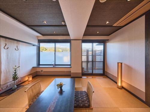a large room with a table and chairs and windows at Wakasa Annex in Nara