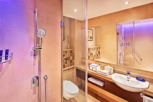 a bathroom with a toilet and a sink and a shower at Vivanta Jammu City Centre in Jammu