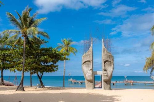 une grande statue sur une plage bordée de palmiers dans l'établissement Sunset Sanato Resort & Villas, à Duong Dong