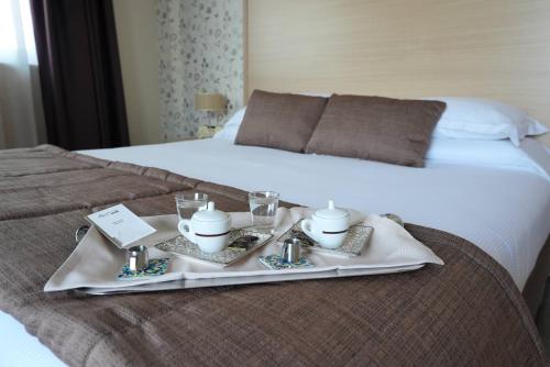 a tray with a breakfastatter on a bed at Hotel Torre Del Sud in Modica