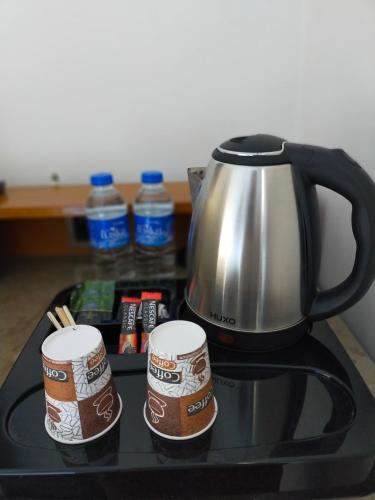 a coffee pot and two cups on a stove at Gala Otel Edirne in Edirne