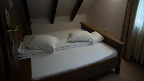 a bed with two pillows on it in a room at Pensiunea Poiana Izvoarelor in Vatra Dornei