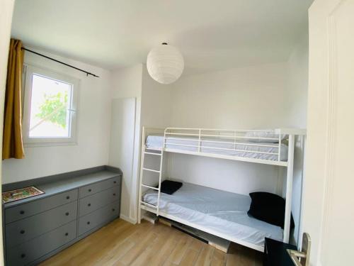 une chambre avec deux lits superposés et une fenêtre dans l'établissement Magnifique appartement climatisé + accès piscine, à Puissalicon