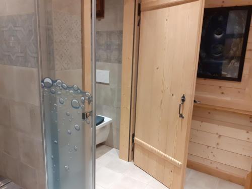 baño con aseo y puerta de madera en Les Abeilles, en Prez-vers-Siviriez