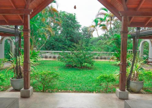 un jardín con palmeras y una valla blanca en Rukmale gedara Bungalow, en Pannipitiya