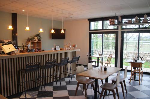 ein Restaurant mit Tischen, Stühlen und Fenstern in der Unterkunft La Gare Soyons in Soyons